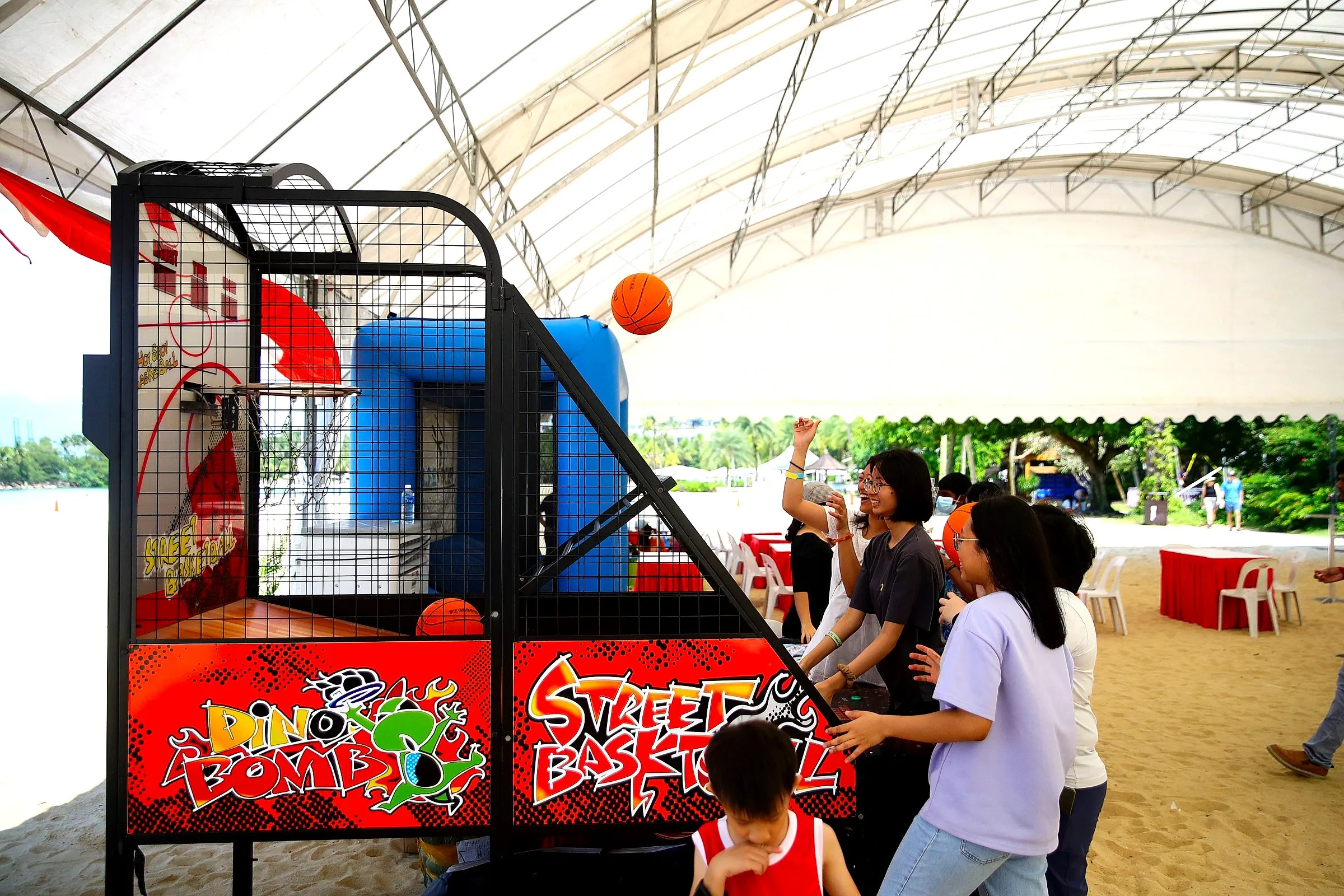 Arcade basketball machine set up on a sandy beach