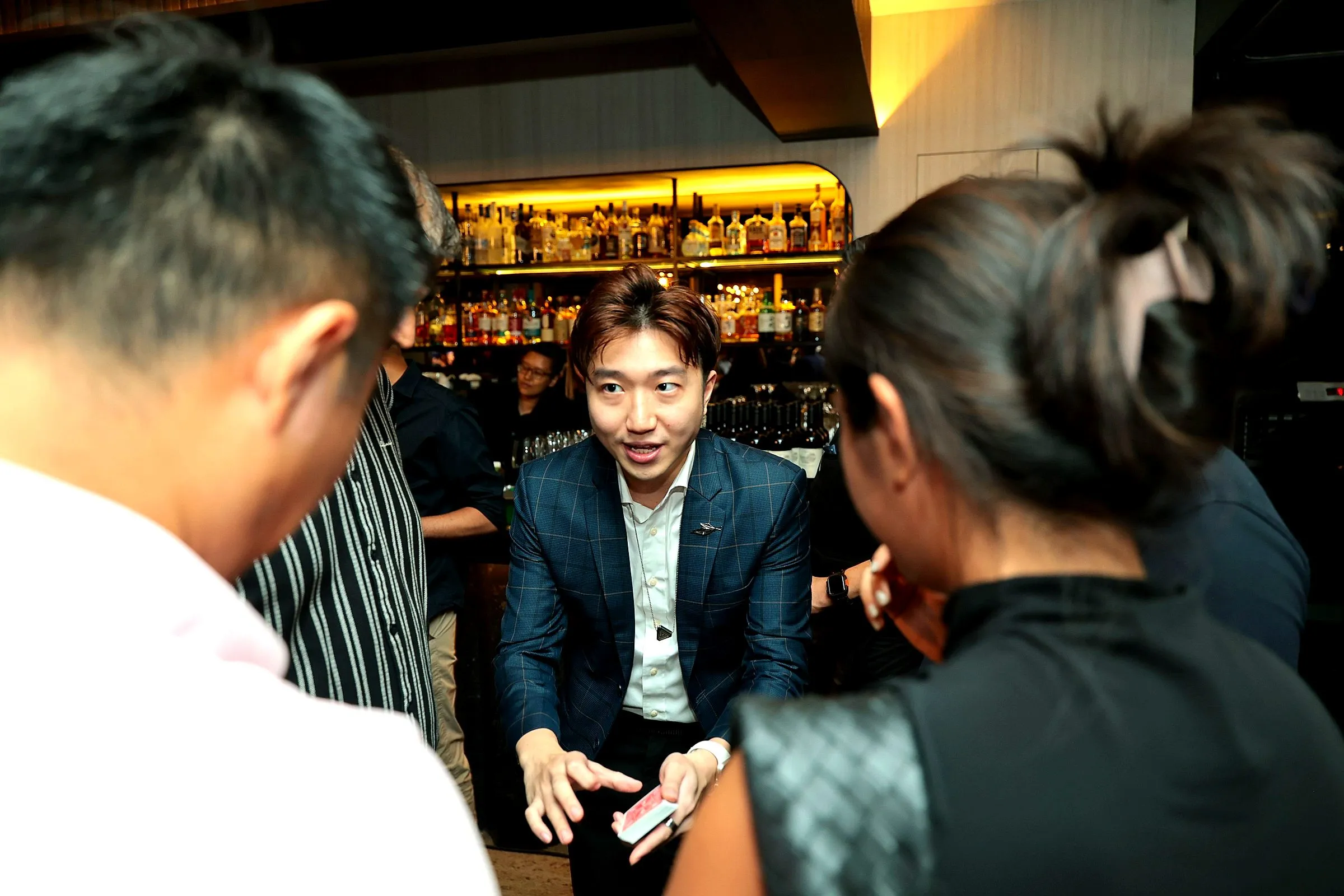 Close-up magician performing a card trick for a small group of guests