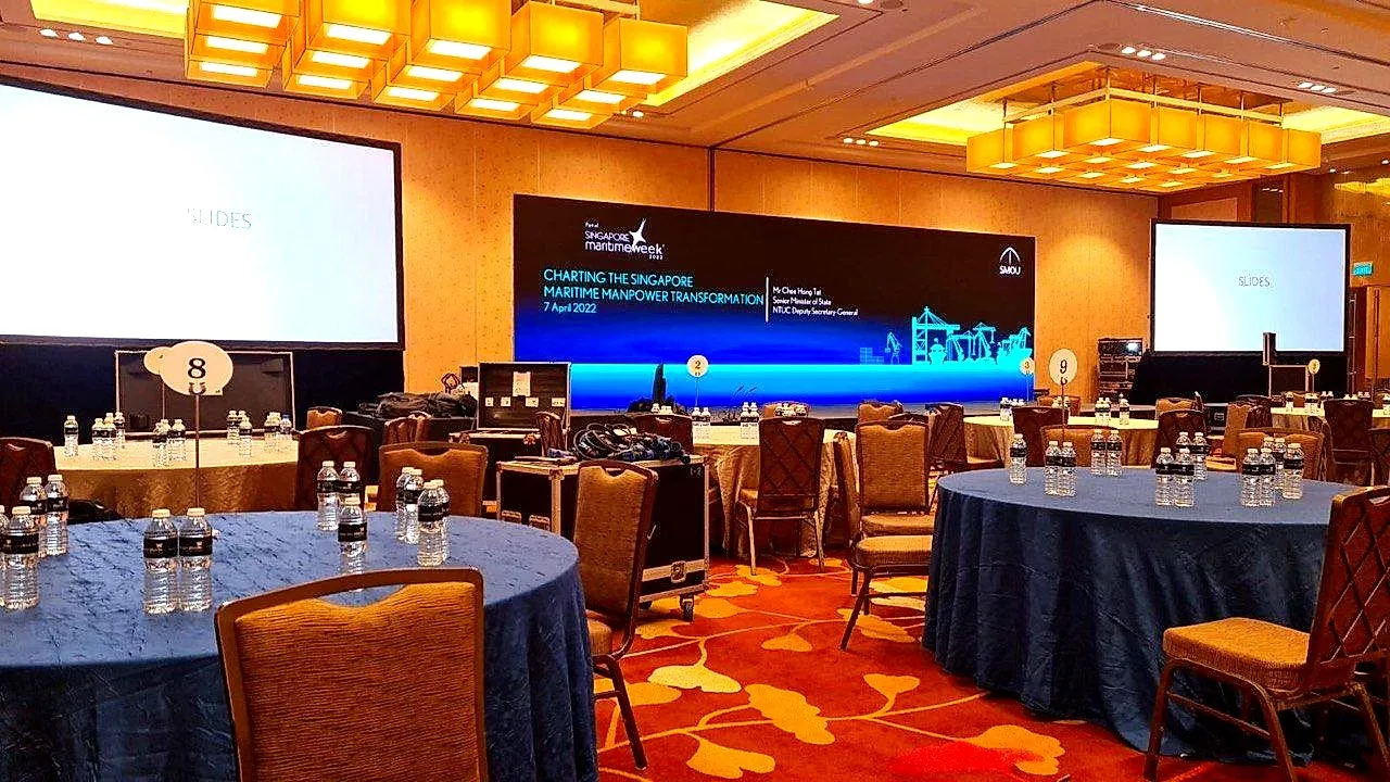 Conference room with banquet tables and twin projection screens