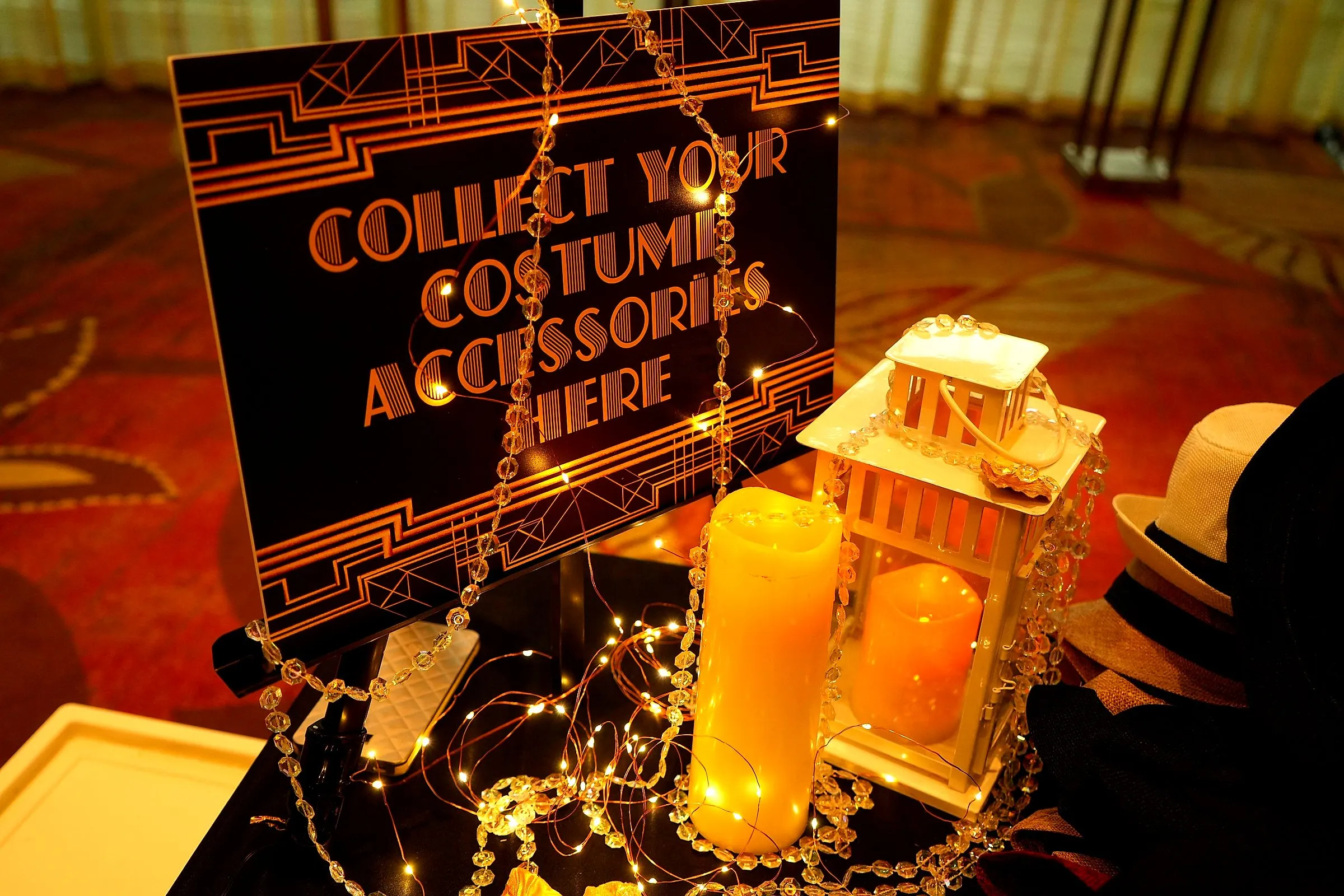 Candlelit prop table inviting guests to collect costume accessories