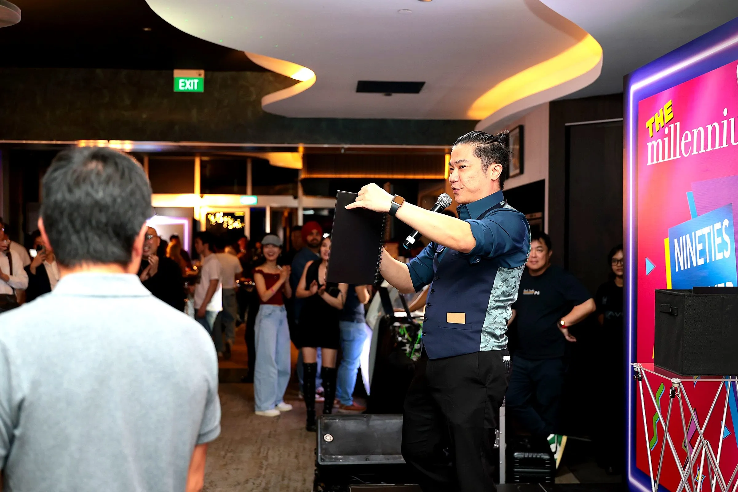 Host with a microphone leading the crowd on a packed party floor