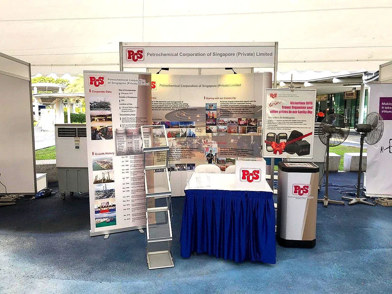 Exhibition booth with pull-up banners and a blue-draped table