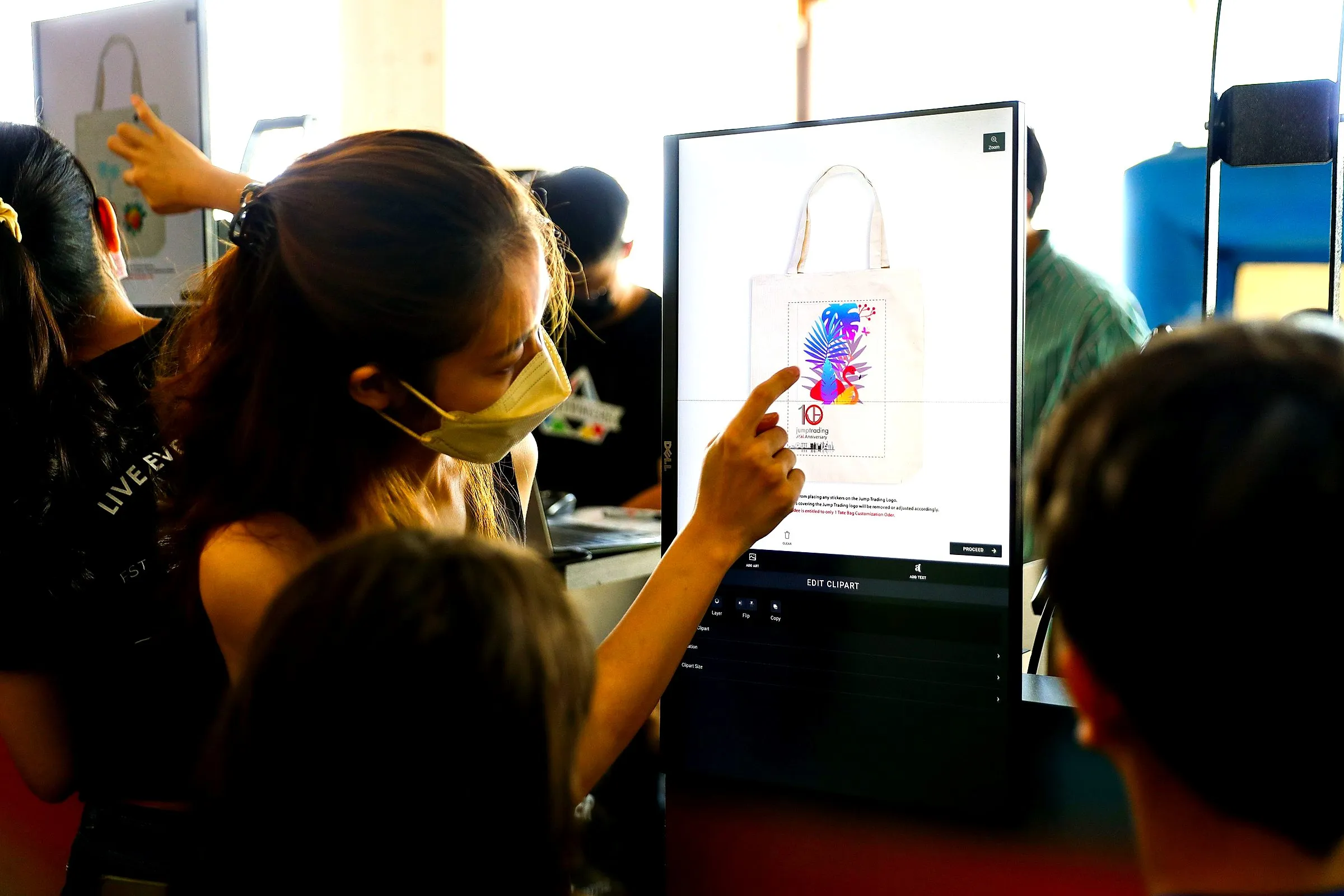 Guest choosing a tote bag design on a touchscreen at a live printing station