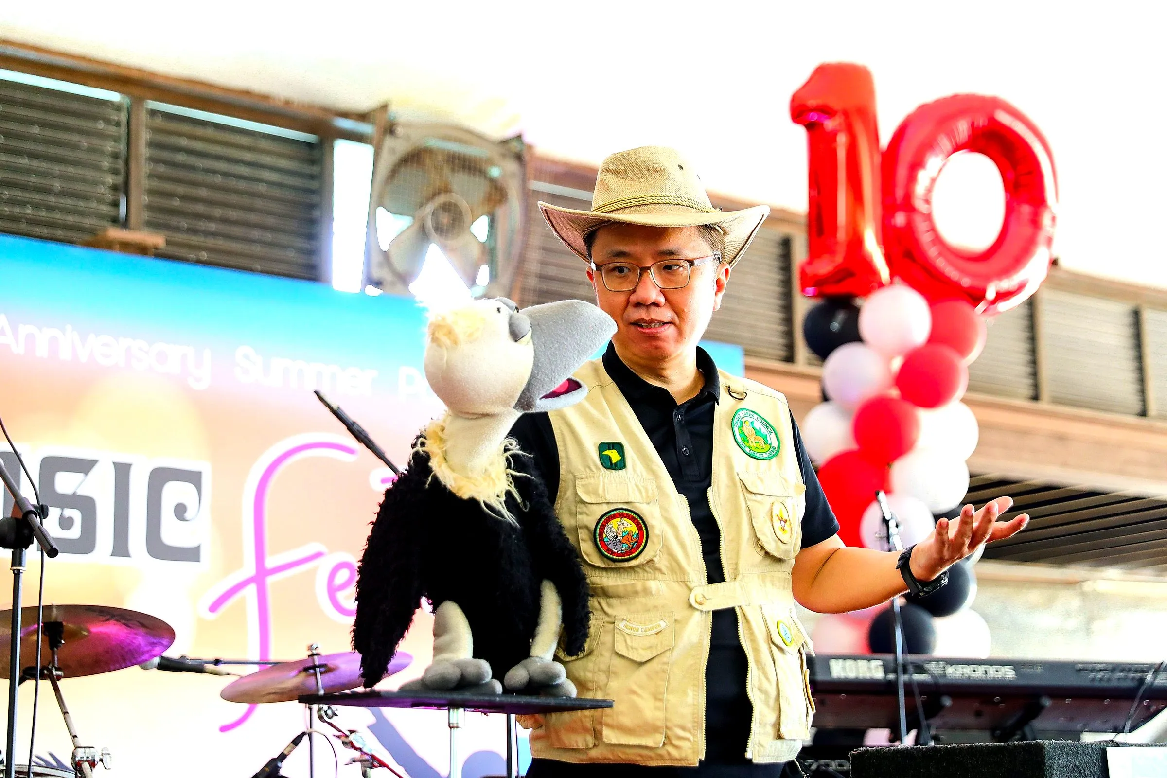 Presenter in a safari hat with a puppet bird entertaining families