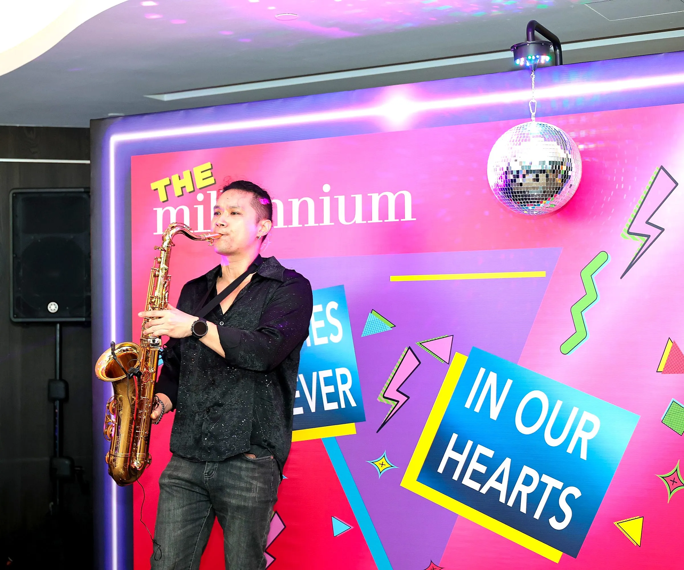 Saxophonist performing in front of a retro-themed backdrop