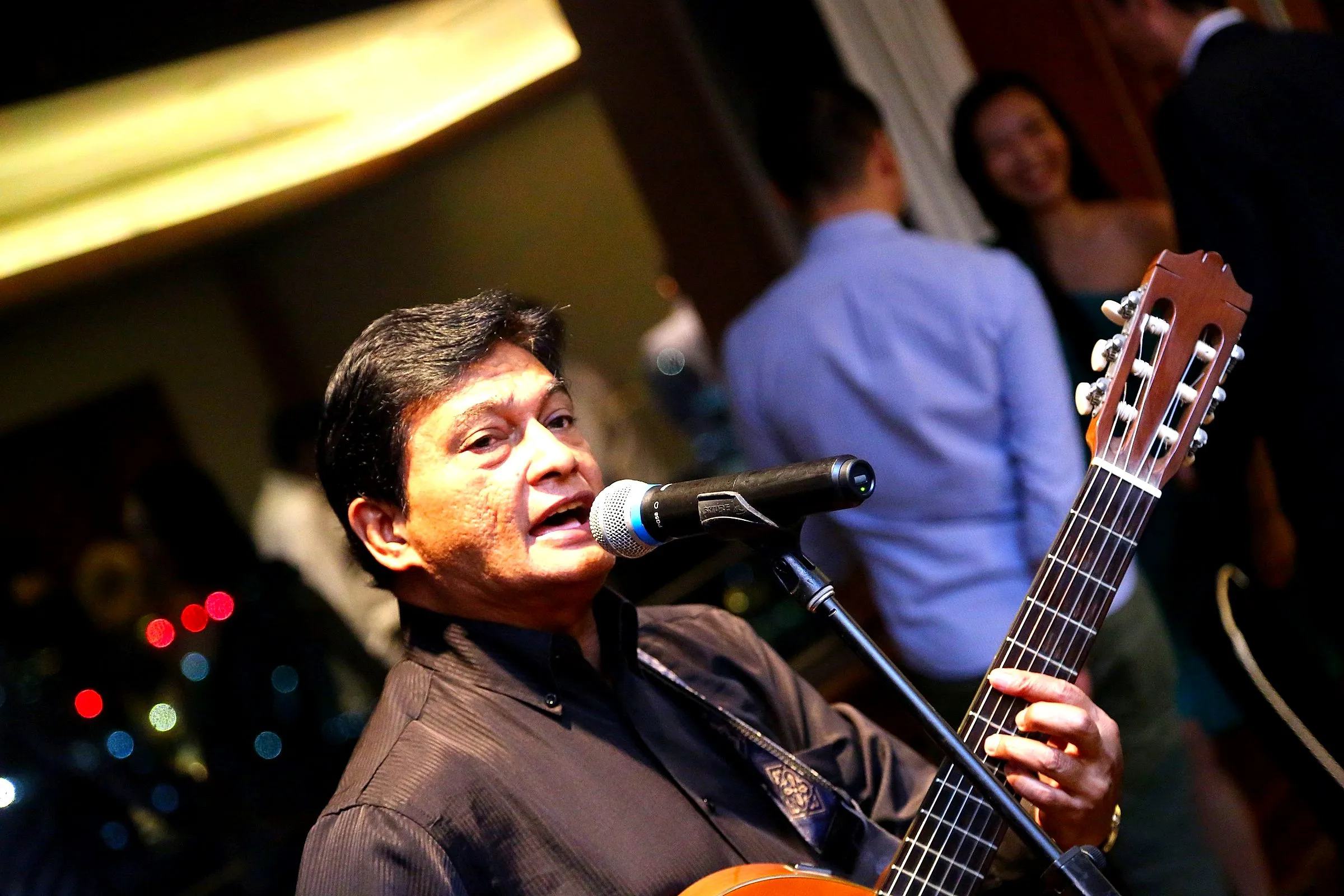 Singer with an acoustic guitar performing for guests during dinner