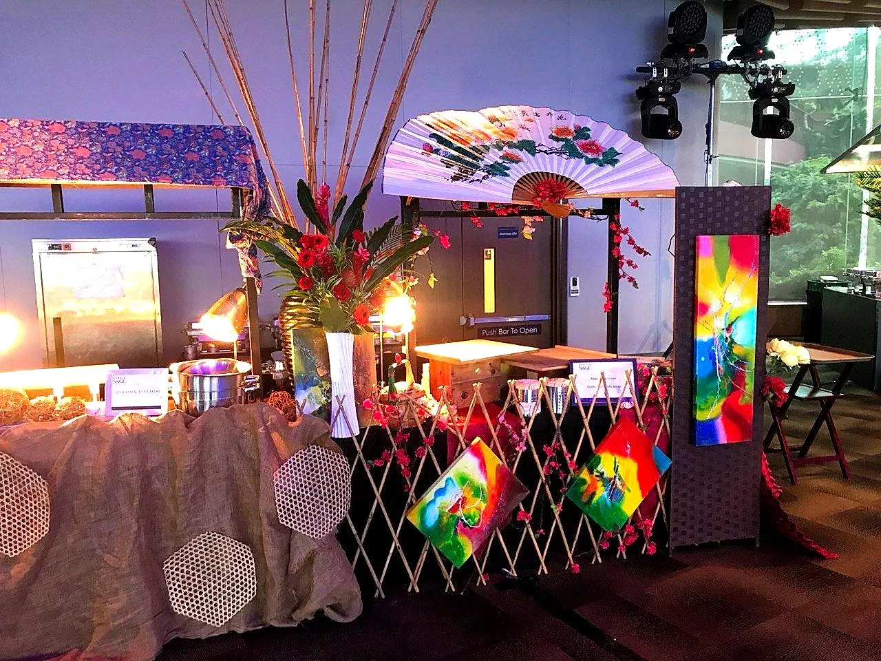 Festive buffet table decorated with fans, flowers and bright screens