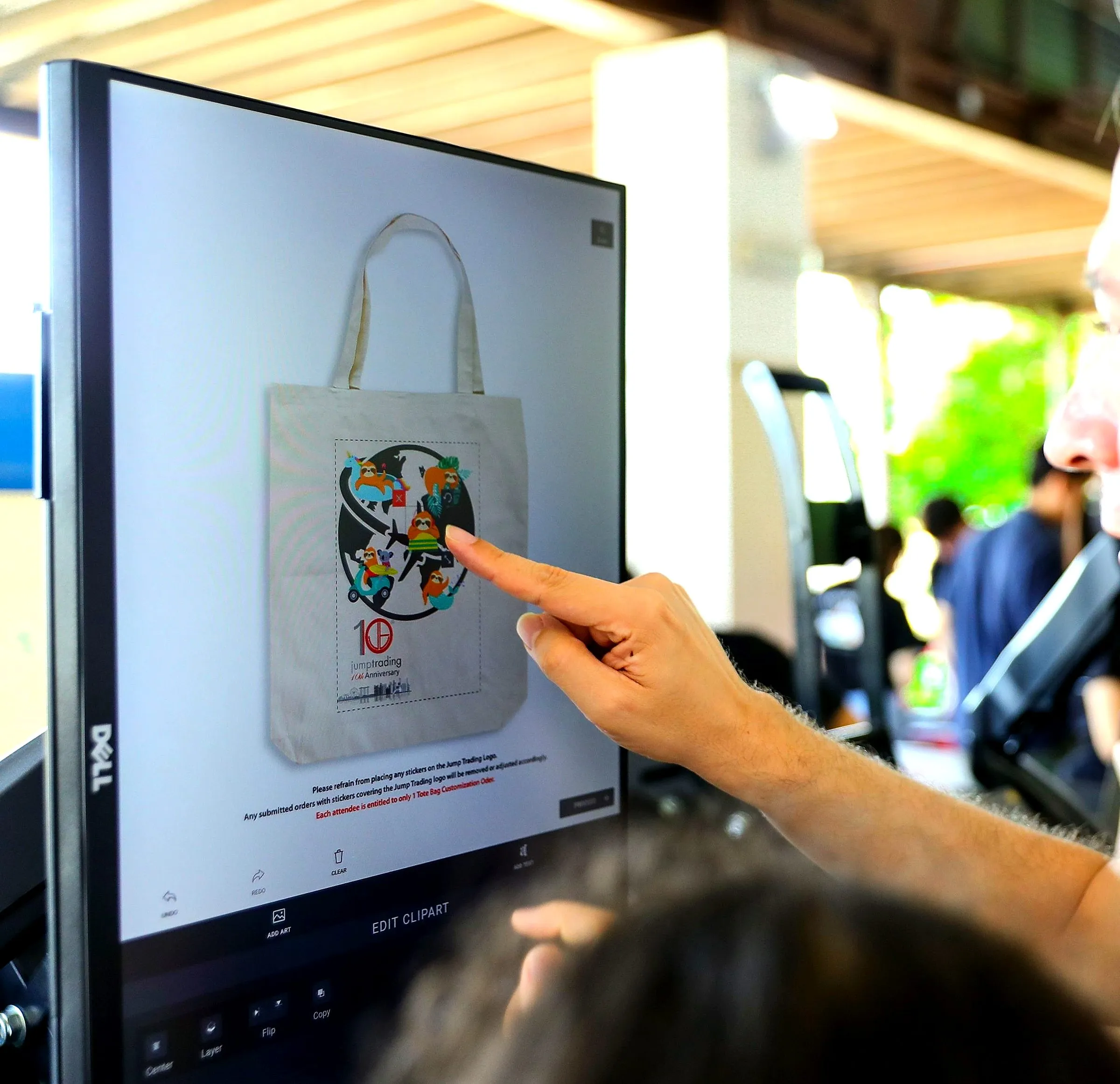Hand touching a screen showing a custom artwork design for a tote bag