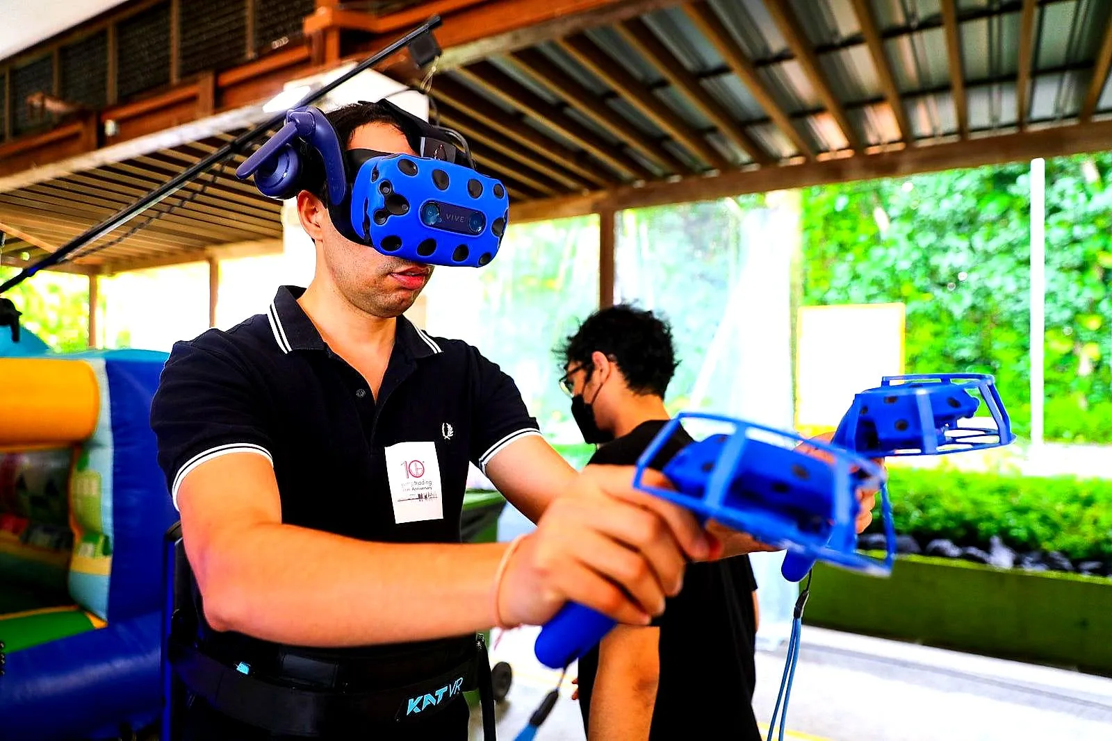 Guest in a virtual reality headset holding controllers beside an inflatable